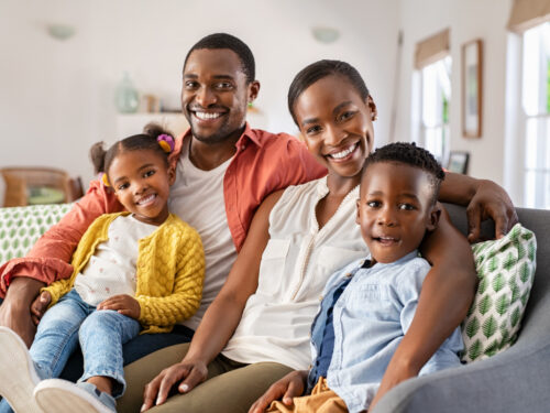 Smiling African American family sitting on couch